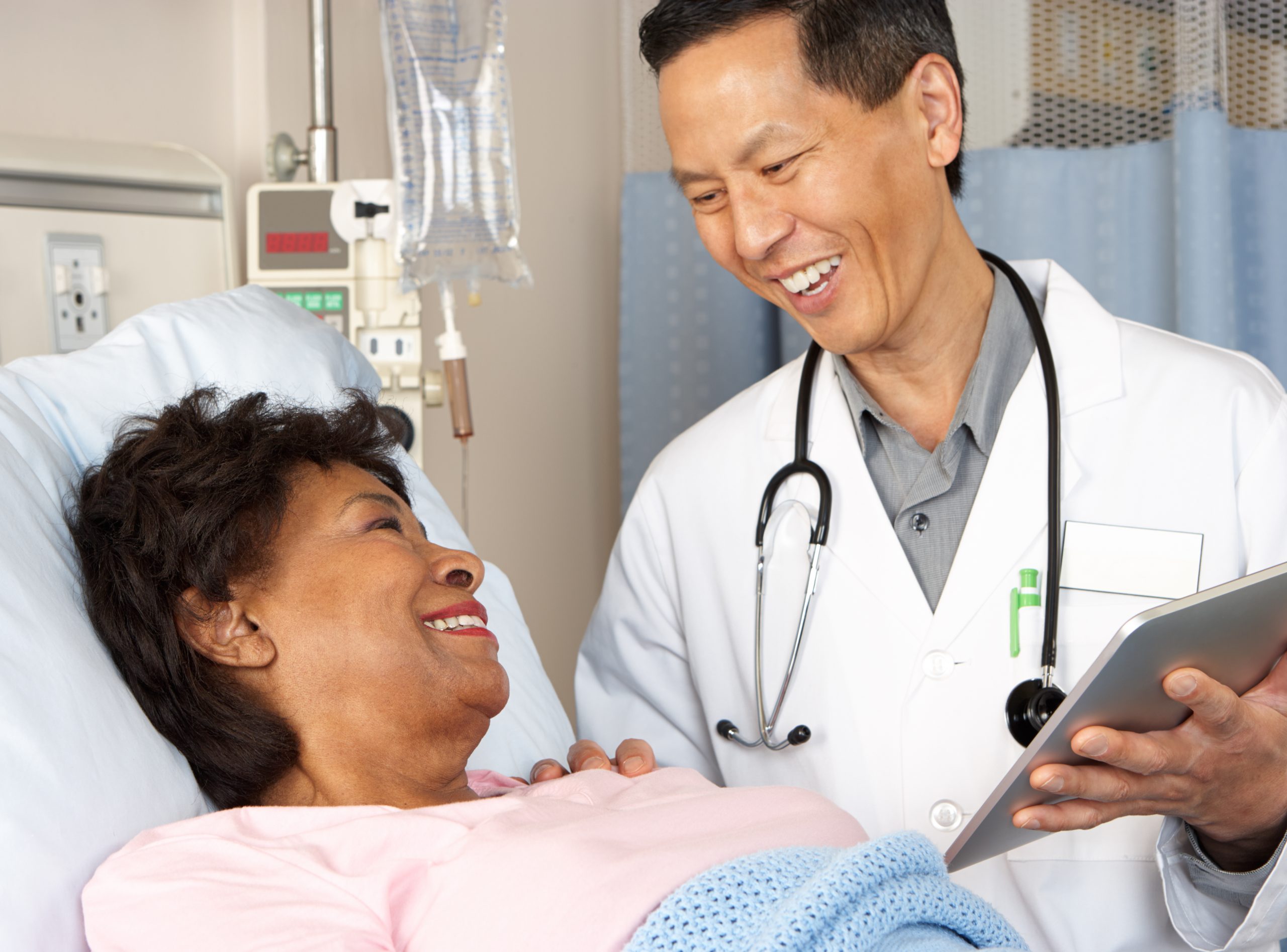 Healthcare staff member rounding and checking on a patient.